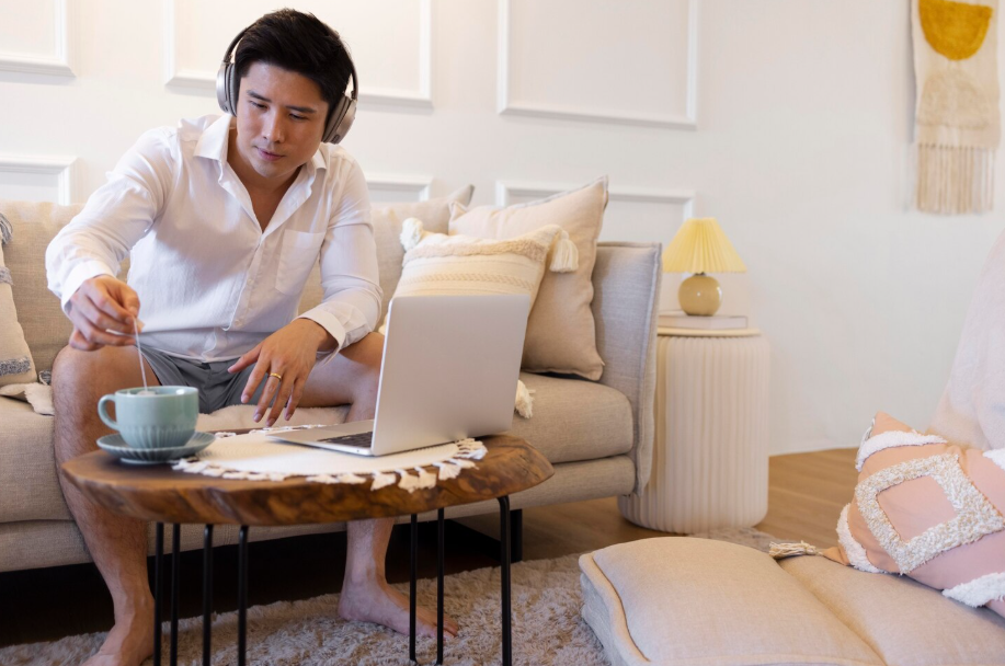 Man in headphones working on time-efficient side hustles at home.