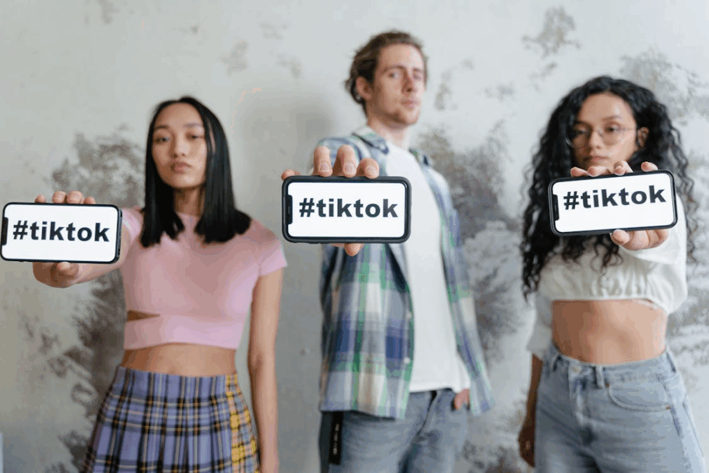 Creators presenting phones with #tiktok, illustrating the viral trend psychology