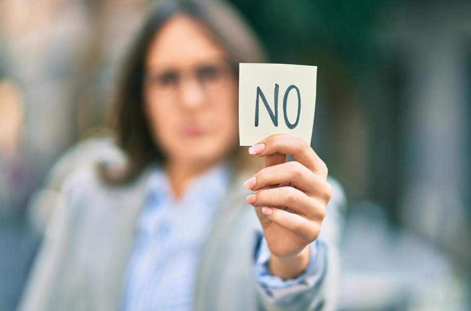 Person holding a note that says NO, demonstrating how to set boundaries