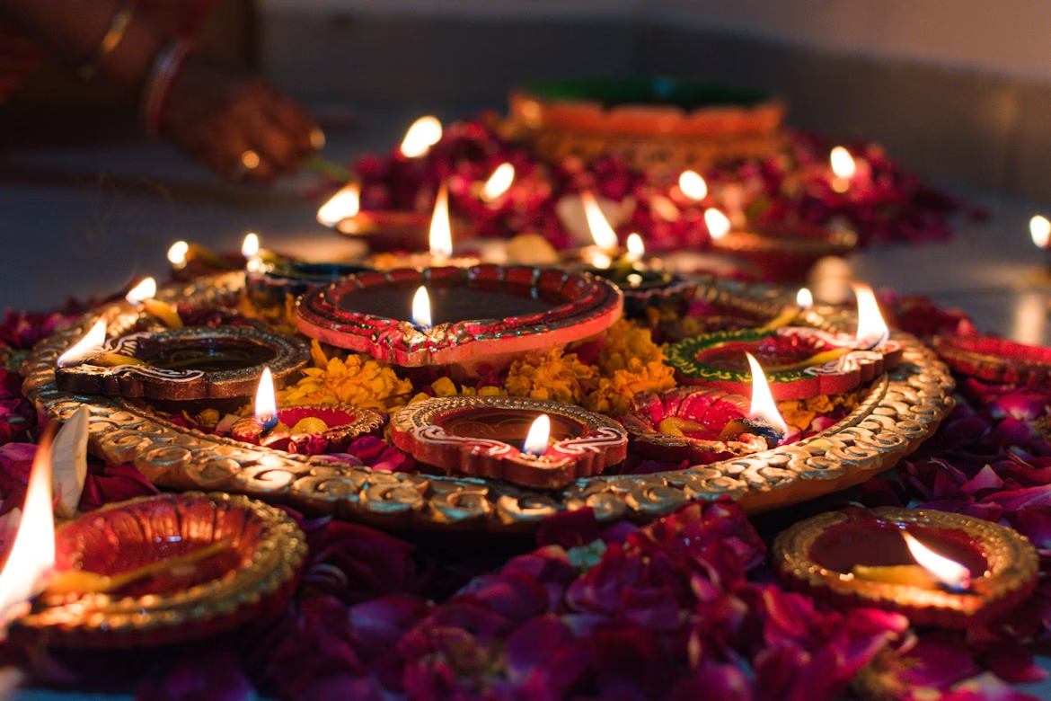 Close-up of lit Diwali diyas arranged on a decorative rangoli