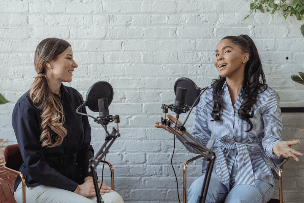 Two women recording a conversational podcast with microphones