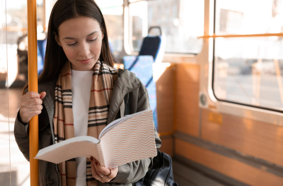Woman reading a paperback on a city bus during her commute